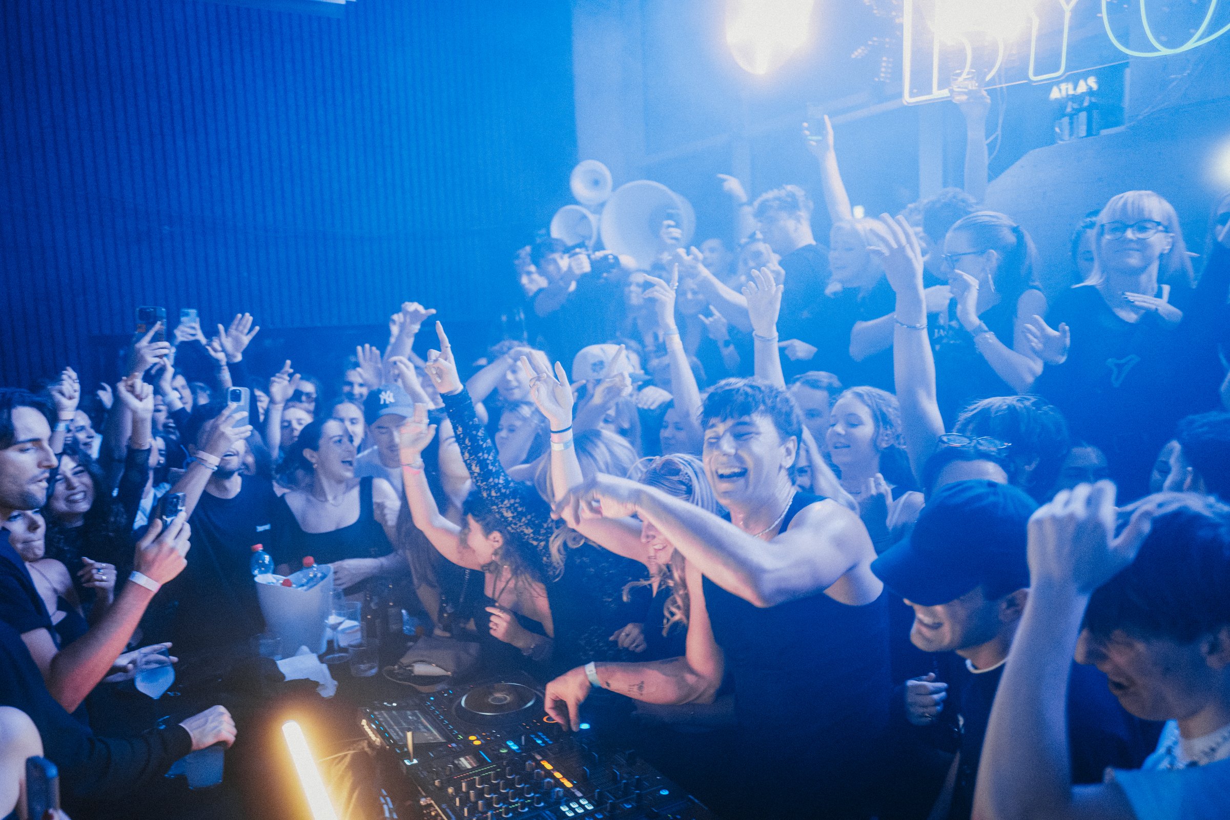 DJ und feierndes Publikum in blauem Licht